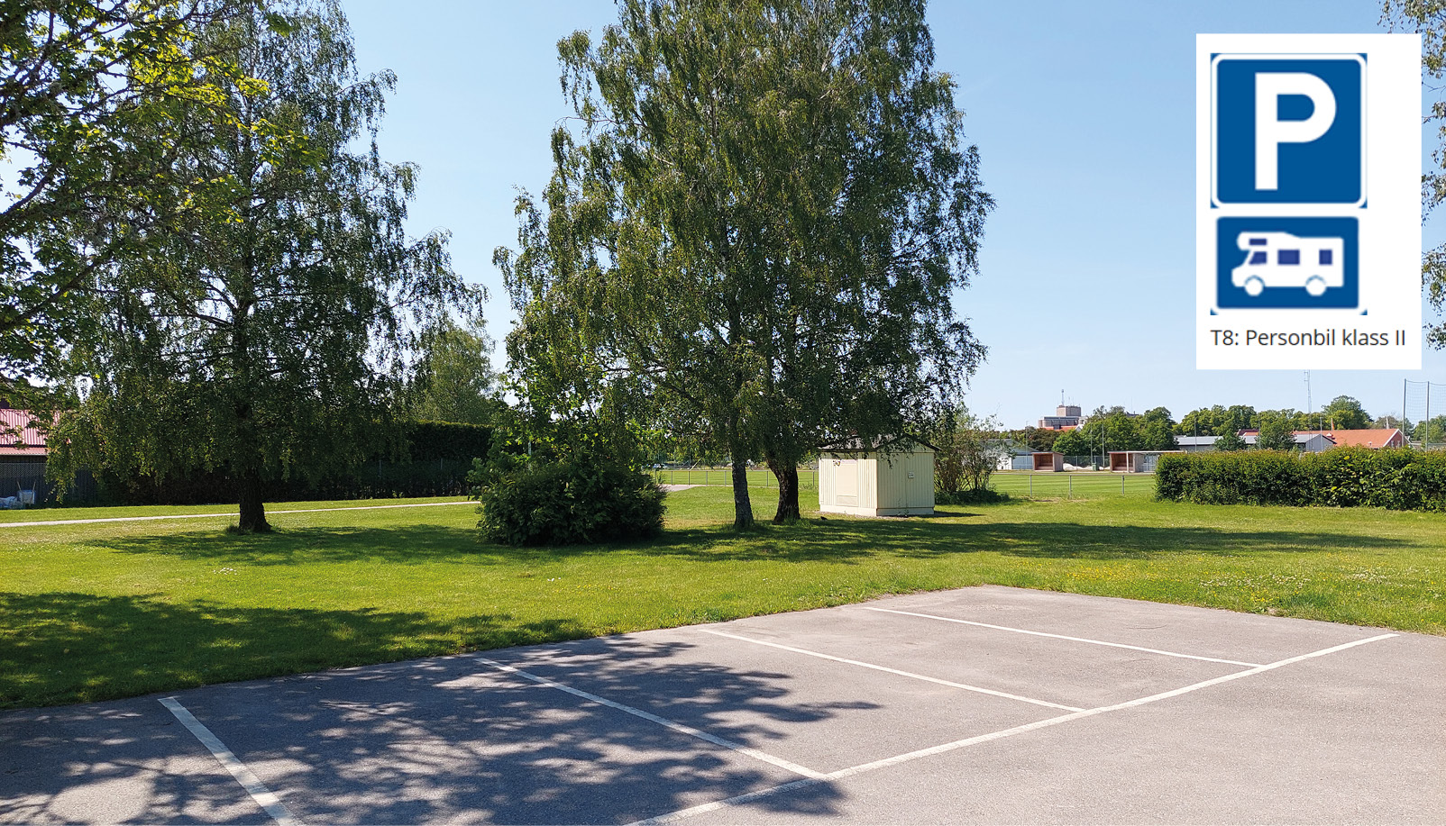 Bild på en asfaltsplan med vita rutor. I hörnet finns en parkeringsskylt och en husbilsskylt