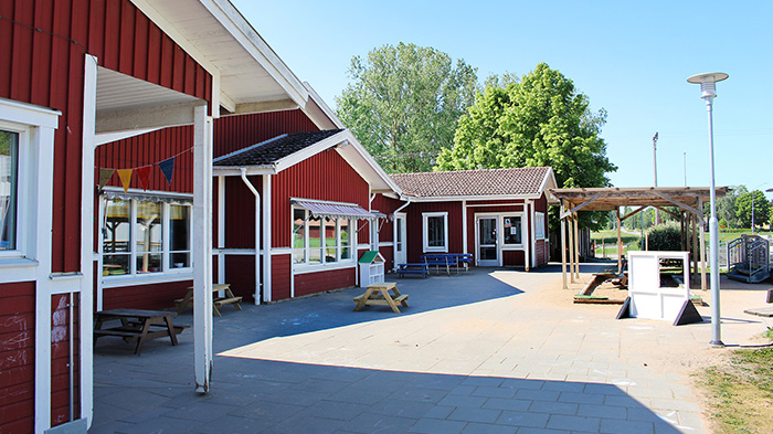 Röda hus med vita knutar och skolgård.